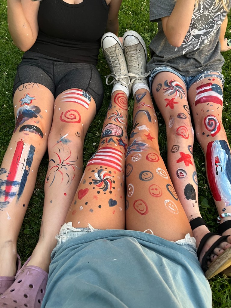 Kids paint legs in Michigan for the fourth of July by Adventurous Leila.