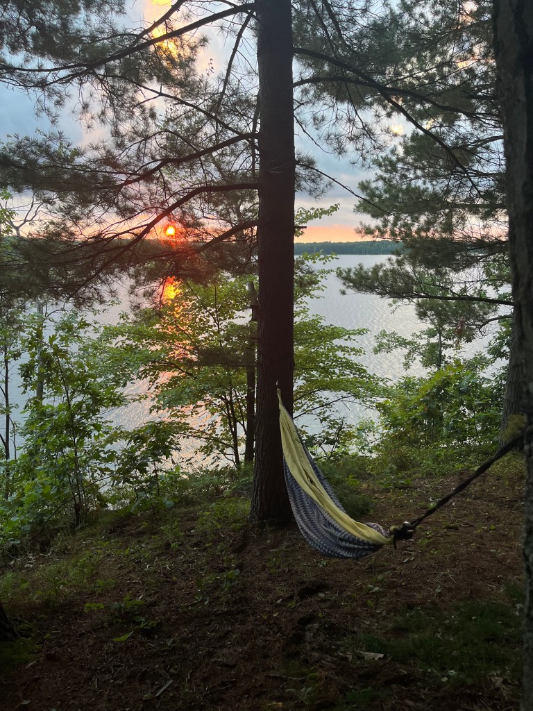A photo of a pretty sunset at a campsite on a lake in Michigan by Adventurous Leila.