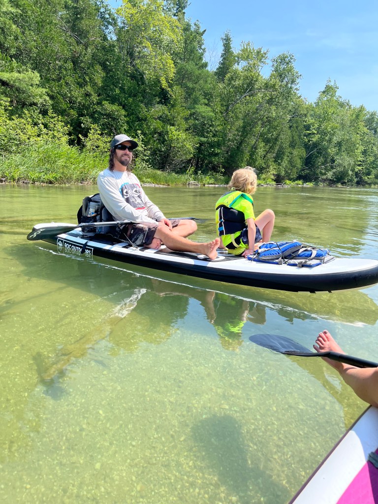 People having a good time paddle boarding on a spring to lake Michigan in Michigan by Adventurous Leila.