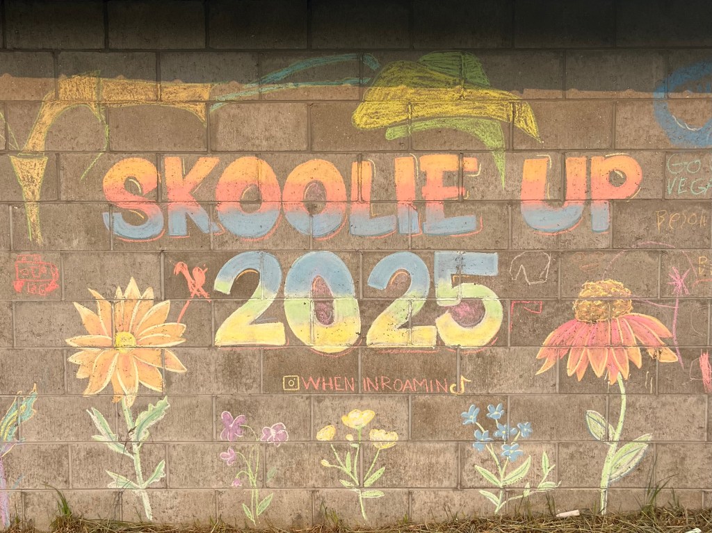 A photo of Skoolie U.P. 2025 chalk art that some of the teens and their teen friends did at a super fun bus travel family friendly event called Skoolie U.P. in the upper peninsula of Michigan. By Adventurous Leila.